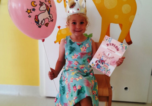 Lilianna w dniu swoich trzecich urodzin pozuje do zdjęcia z prezentami.