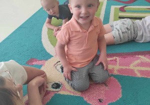 Zdjęcie uśmiechniętego Stefana siedzącego na dywanie.
