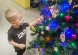 Zdjęcie Mikołaja przy świątecznym drzewku.