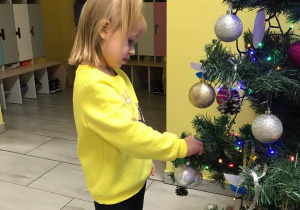 Lena ozdabia świąteczne drzewko.