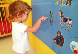 Rozalia otacza pętlą na tablicy szablon papugi.