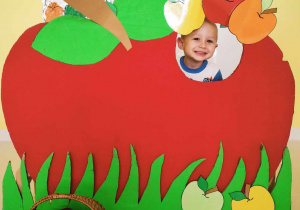 Zdjęcie Leona w tekturowym czerwonym jabłuszku.