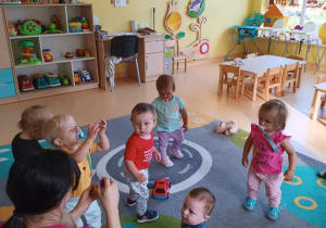 Zdjęcie dzieci podczas zabawy na dywanie.