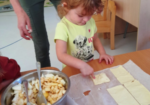 Rozalia formuje swoje ciasteczko z jabłuszkiem.