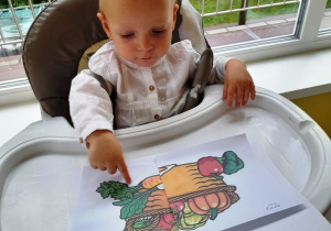 Adelka wskauje paluszkiem na ilustrację z warzywami.
