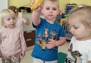 Szymon pokazuje opiekunce robiącej zdjęcie wylosowanego przez siebie banana.
