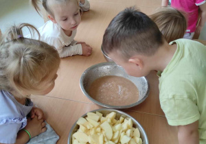 Dzieci przyglądają się metalowej misce ze zblendowanymi gruszkami.