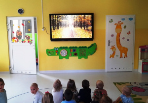 Dzieci oglądające filmik edukacyjny o jesieni.