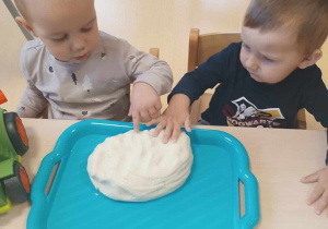 Zdjęcie Dawida i Marcela próbujących nadać kształt chlebkowi.