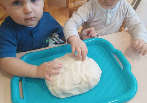 Tobiasz i Nikodem pozują do zdjęcia podczas formowania chlebka z masy solnej.