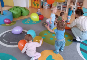Zdjęcie dzieci podrzucających baloniki do góry.