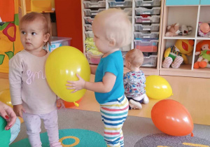 Tobiasz daje Laurze żółty balonik.