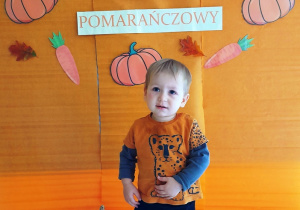 Chłopczyk w Dniu Pomarańczowym na tle ścianki.