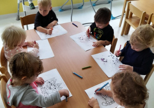 Zdjęcie dzieci malujących kredkami obrazki.