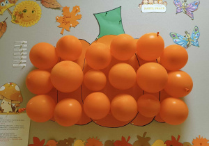 Zdjęcie tablicy grupy Motylki z wykonaną przez dzieci balonową dynią.
