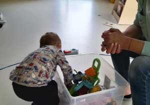Chłopiec sięga do pudełka po zabawkę.