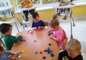 Dzieci z grupy Biedroneczki przy stoliku podczas zajęć.