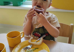 Zdjęcie Wiktora degustującego marchewkową muffinkę.