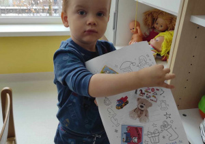 Wojciech pozuje do zdjęcia ze swoim wyklejonym wymarzonymi zabawkami listem.