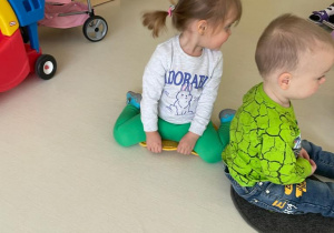Zdjęcie dzieci siedzących na kolorowych kołach.