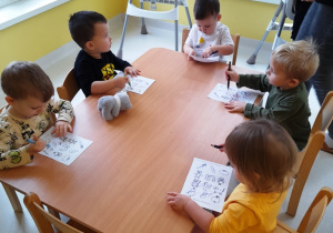 Dzieci z grupy Biedroneczki siedzące przy stole podczas zajęć.