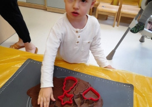 Chłopiec wykrawa z ciasta gwiazdkę.