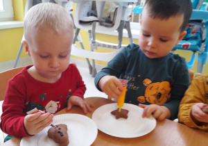 Dwoje dzieci podczas dekorowania ciasteczek.