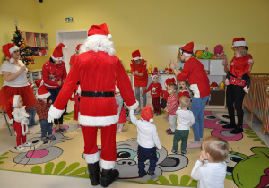 Dzieci z grupy Biedroneczek tańczące ze Świętym Mikołajem.