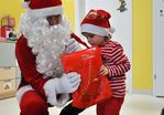 Święty Mikołaj wręcza prezent Adasiowi.