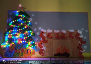 Zdjęcie tablicy grupy Pszczółki ze świątecznymi pracami przy zgaszonym świetle.