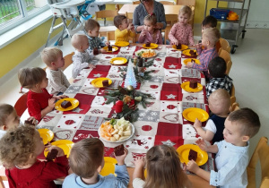 Dzieci z grupy Biedroneczki siedzące przy świątecznym stole.