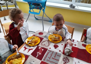 Dzieci jedzą świąteczny obiad.
