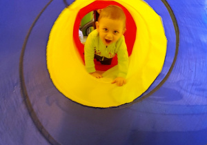 Mały chłopczyk w matriałowym tunelu.