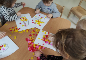 Dzieci z grupy Pszczółki dekorują swoje kwiatki.