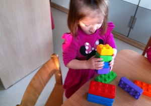 Dziewczynka układająca wieżę.