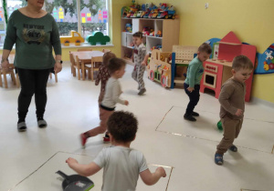 Zdjęcie dzieci podczas zabawy muzyczno - ruchowej.