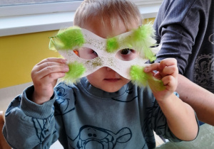 Chłopiec przymierza zrobioną przez siebie maskę.