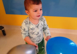Chłopiec trzymający dwa baloniki.