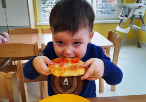 Chłopczyk próbuje swojej pizzy.