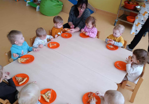 Zdjęcie dzieci próbujących wykonanej przez siebie pizzy.