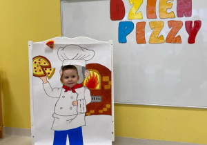 Chłopczyk pozuje na ściance w Dzień Pizzy.