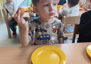 Zdjęcie Tymoteusza podczas jedzenia małego pączuszka.