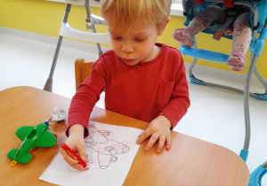 Chłopiec koloruje ilustrację.