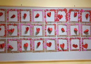 Zdjęcie tablicy grupy Pszczółki z wykonanymi przez dzieci serduszkowymi ramkami z okazji Walentynek.