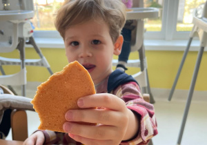 Chłopiec pozujący z ciasteczkiem w kształcie serca.
