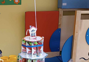 Zdjęcie tortu urodzinowego dla dzieci, przywiezionego na srebrnym kuchennym wózku.