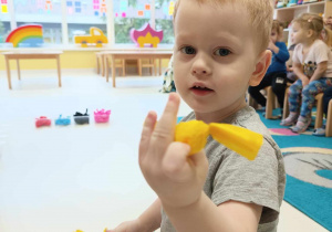 Zdjęcie Szymona trzymającego w dłoni żółty cukierek.