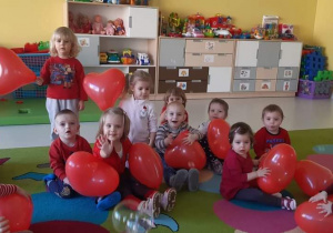 Zdjęcie dzieci z grupy Żabki z balonami w kształcie serduszek.