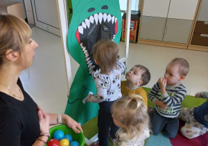 Zabawa dzieci w karmienie dinozaura.