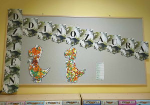 Zdjęcie tablicy grupy Pszczółki z ozdobionymi przez dzieci szablonami dinozaurów.